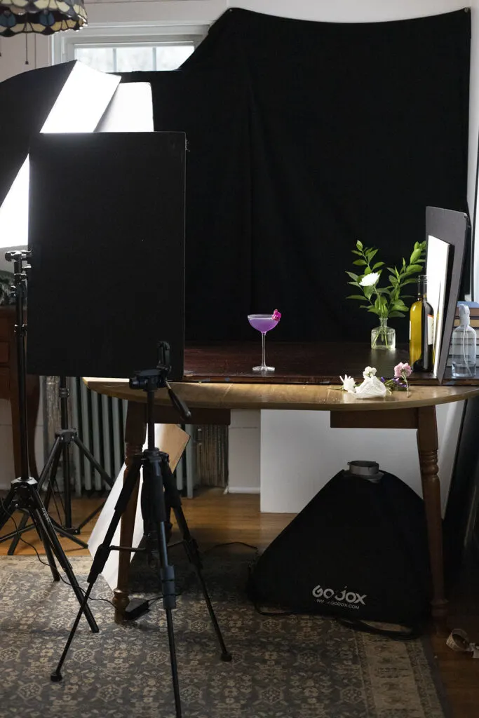 a photo studio setup with lighting and black backdrop.